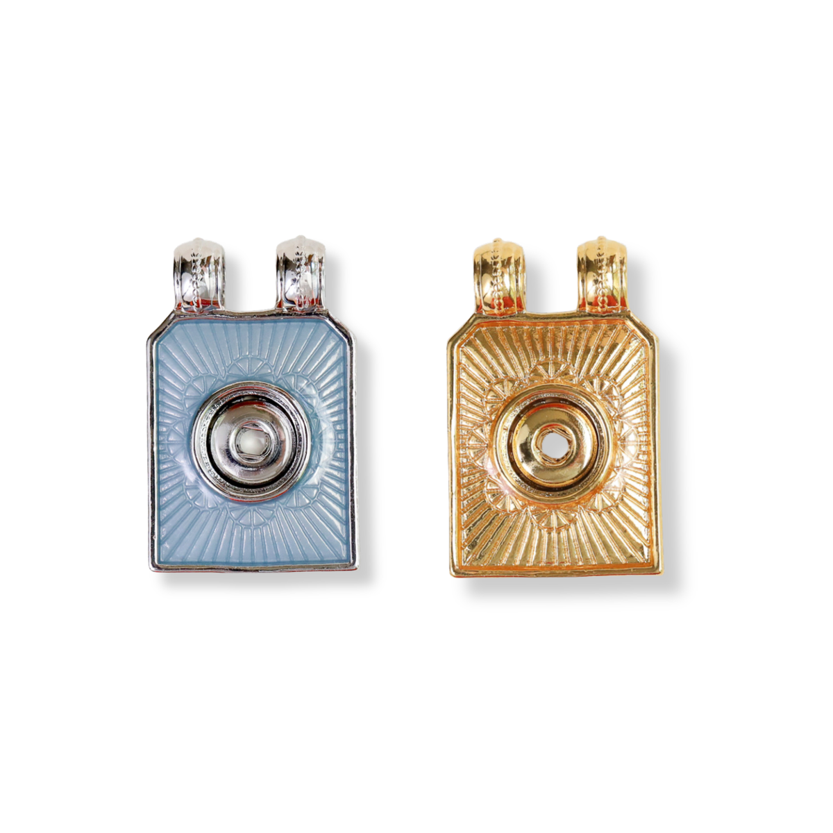 Two rectangular pendant-style jewelry pieces shown side by side on a plain white background. The left piece is light blue with a silver-toned circular center and silver top prongs. The right is the same style but in all gold. 