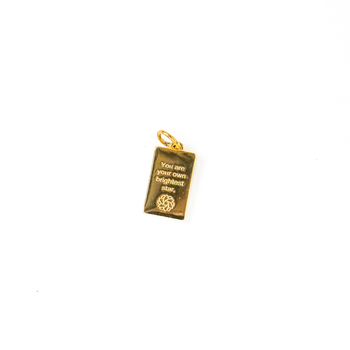 This shows the back of a rectangular pendant charms on a white background. The golden charm is in engraved with the message, "You are your own brightest star" with a Style Dots Logo beneath it. 
