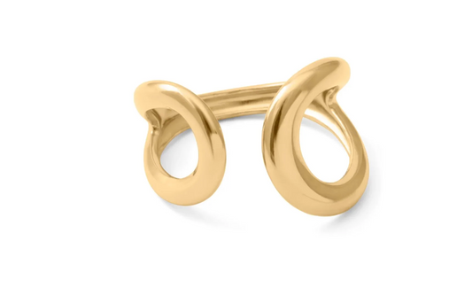 A polished gold ring with a unique openwork design resembling two interlocking loops, shown on a clean white background. 