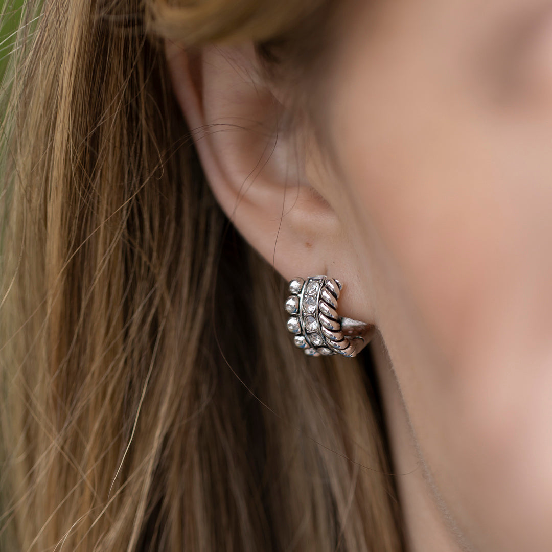 Dainty jewelry in antiqued silver on huggy hoop earrings