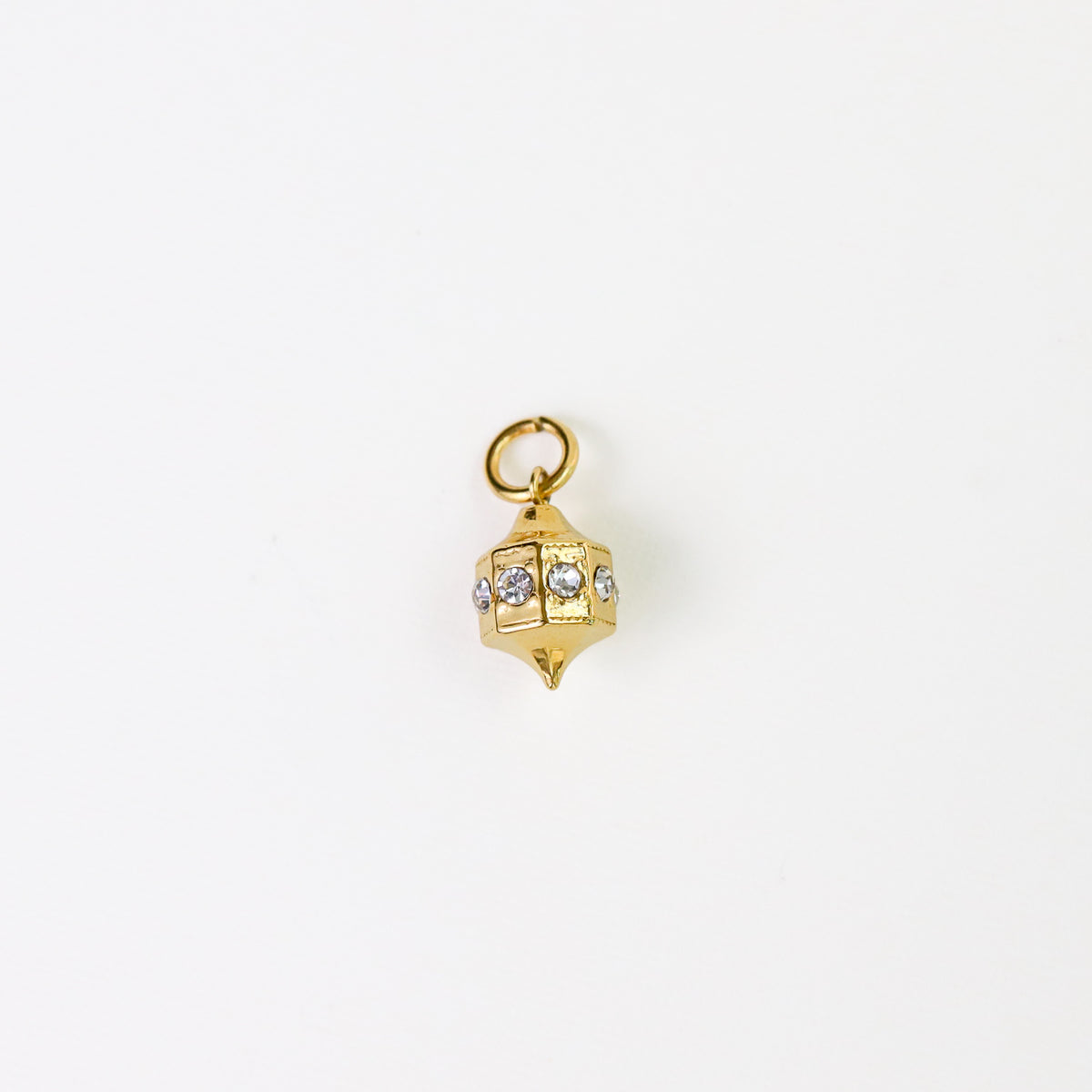 A small gold-toned pendant charm shaped like a geometric lantern, with a top loop and several clear rhinestone accents, photographed on a plain white background.