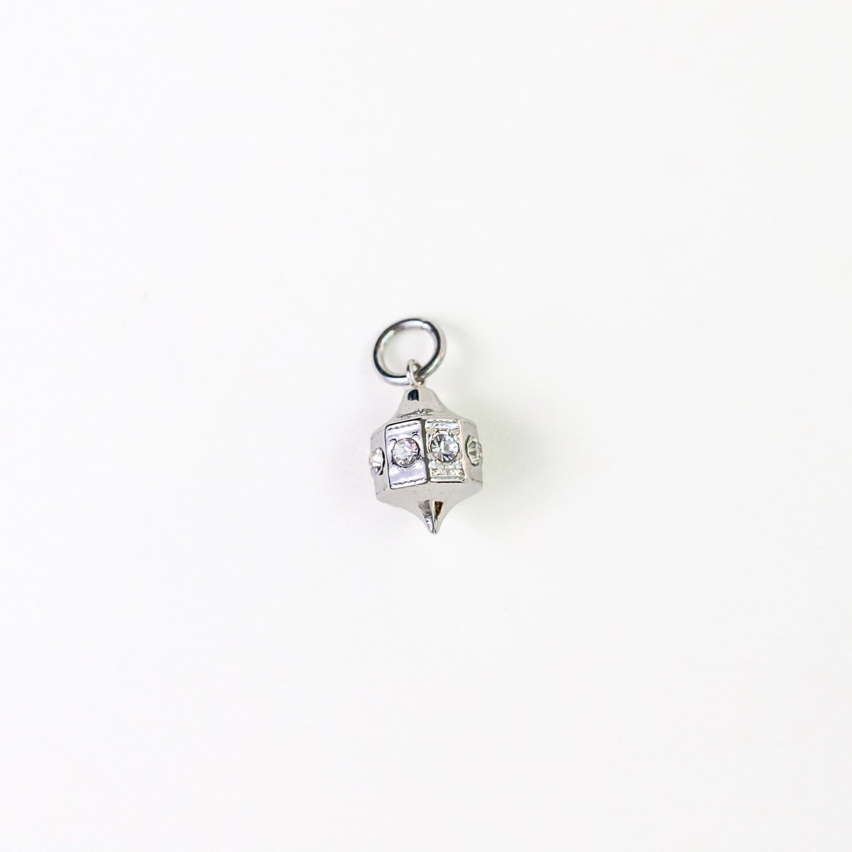 A silver-toned geometric lantern shaped charm with clear rhinestones, shown on a plain white background.
