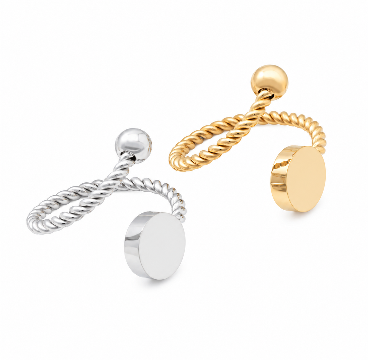 Two minimalist rings on a white background, one in polished silver and one in polished yellow gold color. Each features a twisted rope band, a small spherical bead, and a flat circular disc that can be engraved.