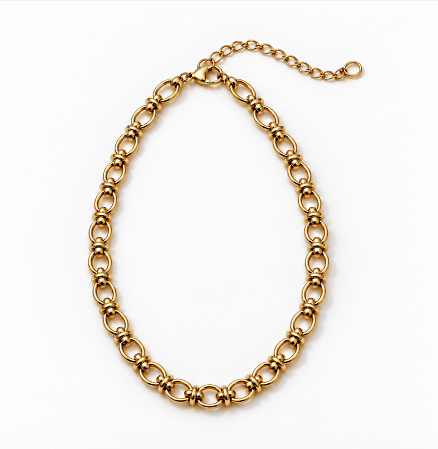 A gold-toned metal link chain necklace with elongated oval links and a short extender chain with a clasp, photographed on a plain white background.