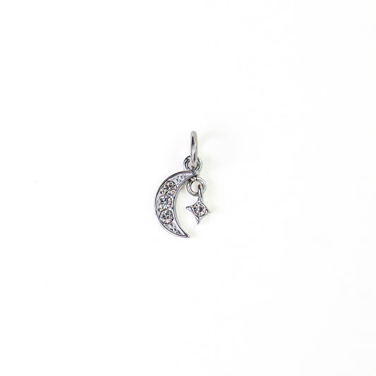 A silver crescent moon and star charm, embellished with clear rhinestones, shown on a plain white background.