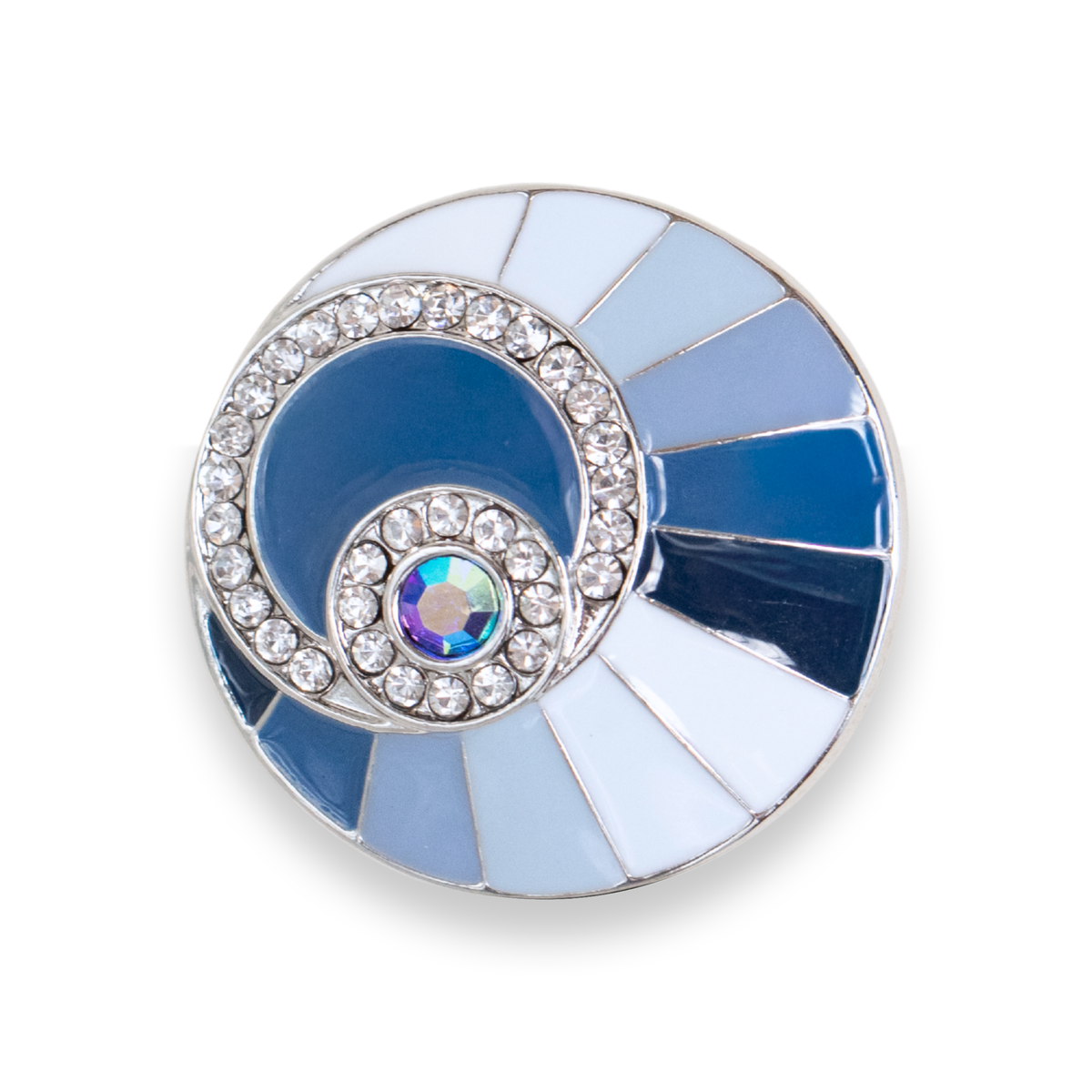 A round silver-toned Dot featuring a halo of clear crystals and a central sunburst design with light blue enamel, a blue iridescent crystal, set against a plain white background. This size is the Statement size released in September/ October 2026