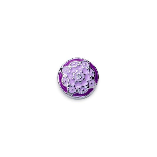 A round purple and lavender enamel pin featuring a flower design with silver metal outlines and a central silver floral motif embellished with small clear rhinestones, set against a plain white background.