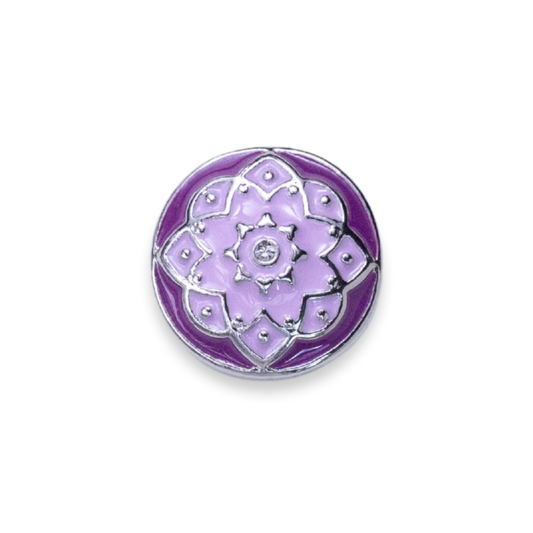 A round purple and lavender enamel pin featuring a flower design with silver metal outlines and a central silver floral motif embellished with small clear rhinestones, set against a plain white background.