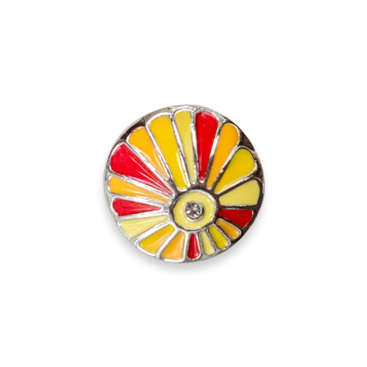 A round enamel Dot featuring a stylized sunburst design with alternating yellow and red petals, outlined in silver metal and set against a plain white background.