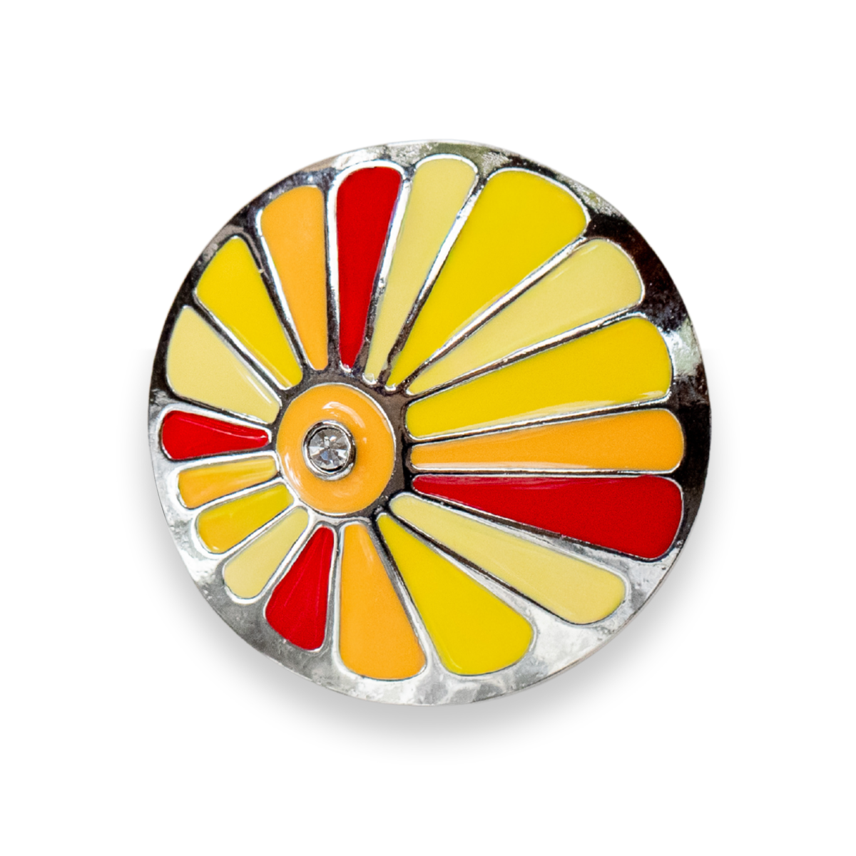A round enamel Dot featuring a stylized sunburst design with yellow, orange, and red segments outlined in silver metal, with a small clear rhinestone in the center, shown on a white background.