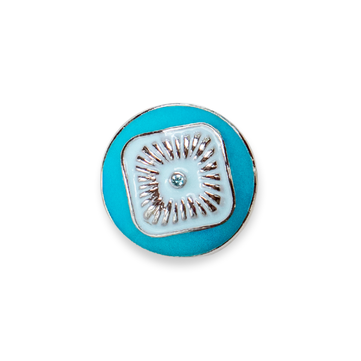 A round turquoise blue enamel Dot with a silver-toned metal border and a central square design featuring a white background, silver-toned sunburst rays set inside a light blue middle on the turquoise Dot, and a small clear rhinestone. 