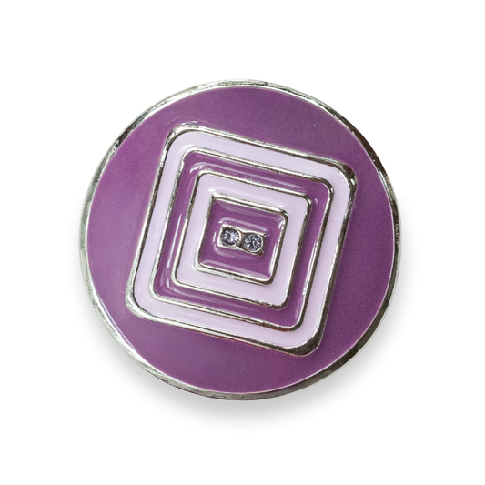 A round purple enamel button with concentric square and rectangular geometric patterns in the middle of the button, outlined in silver-tone metal, featuring two small clear rhinestones at the center, shown on a white background.