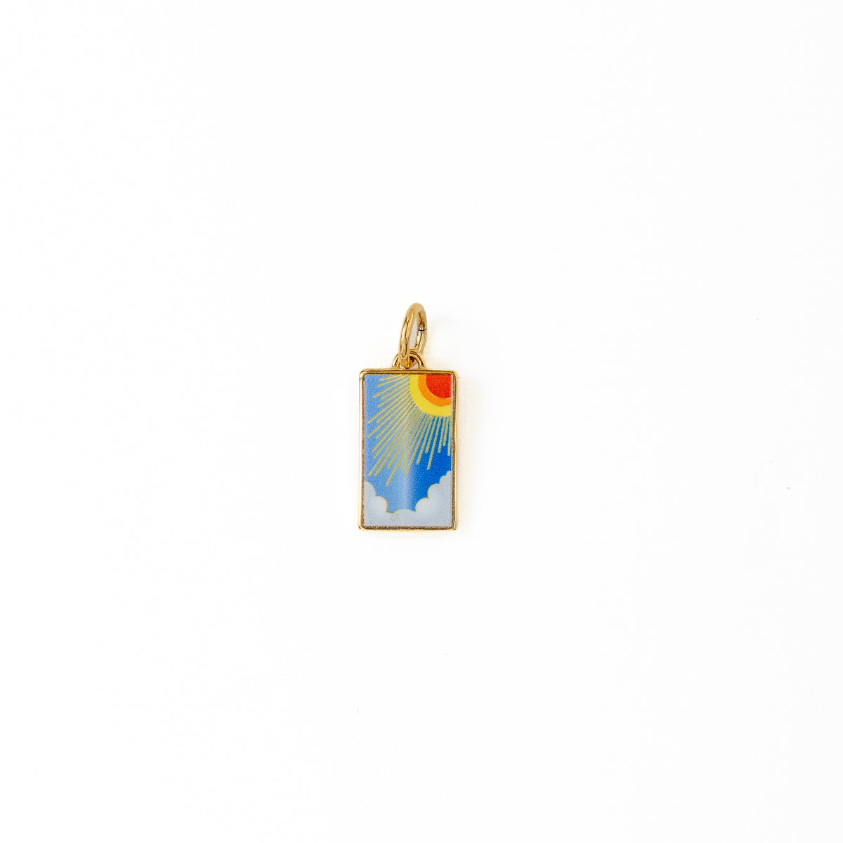 A small rectangular gold charm pendant featuring an enamel sunburst design over a blue sky with white clouds, centered on a plain white background.